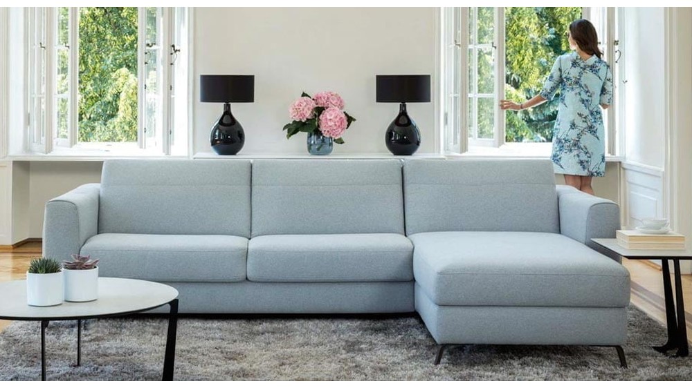 Kler šviesiai mėlyna kampinė sofa Bolero su pufu interjere