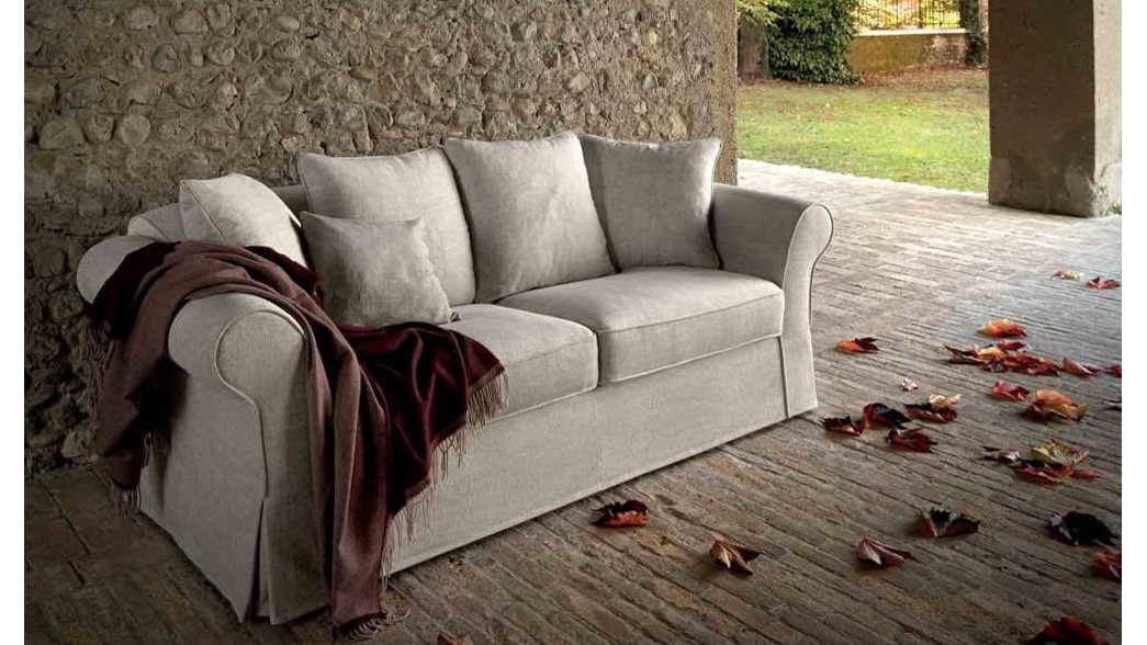Smėlio spalvos sofa Atena su raudona antklode akmenų kiemelyje, SAMOA DIVANI