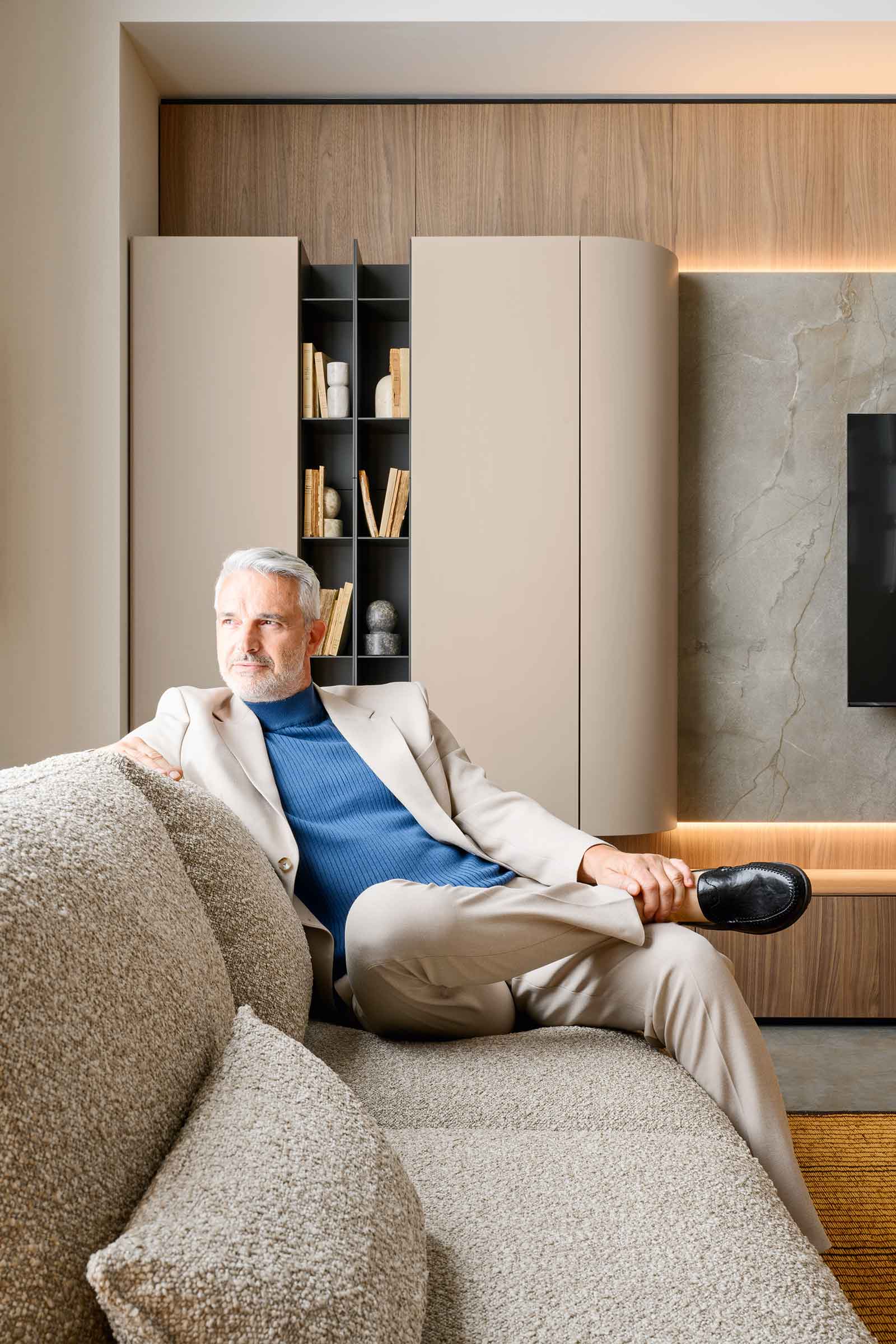 Smėlio bouclé sofa Mac su sėdinčiu žmogumi svetainėje, portretinis kadras, Novamobili