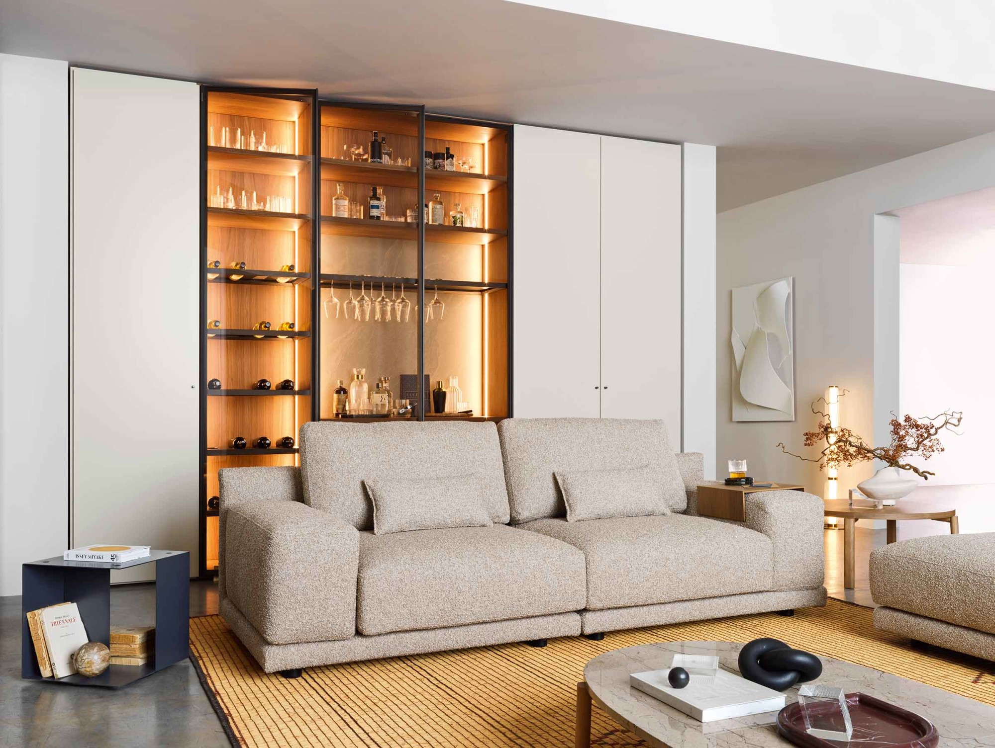 Smėlio bouclé sofa Mac su storais porankiais svetainėje prie vitrinos, Novamobili