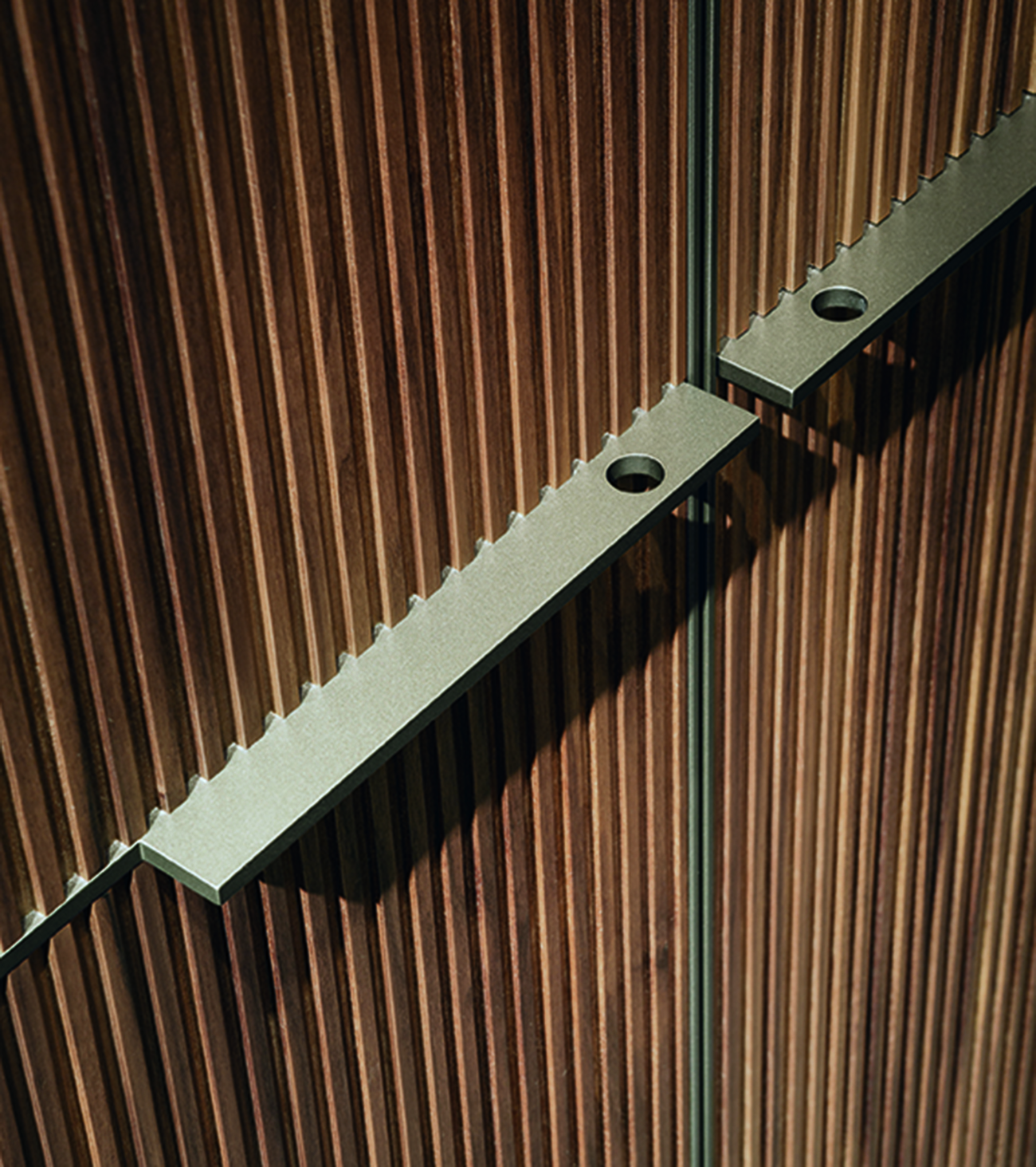 Šviesaus metalo rankenų ir rievėto riešutmedžio durų detalė, Seryasse, Lema